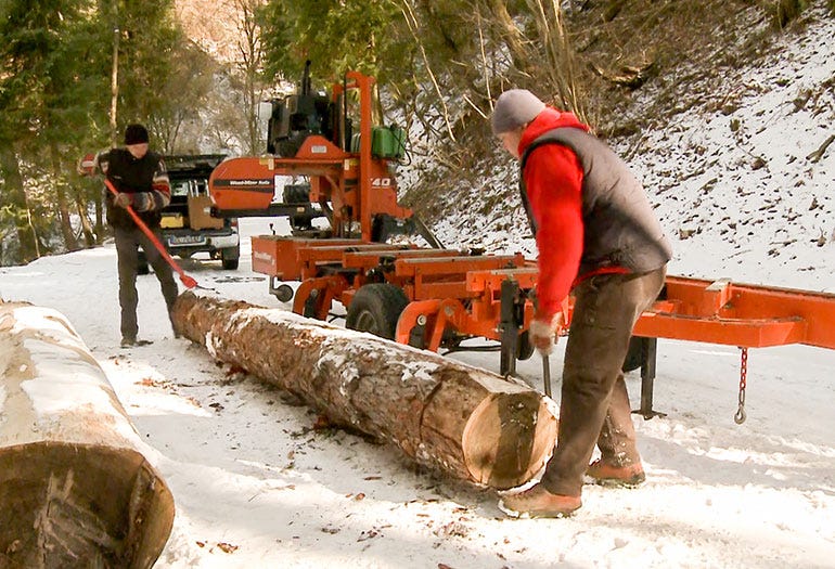 A hydraulic loader quickly uploads a log to the sawmill