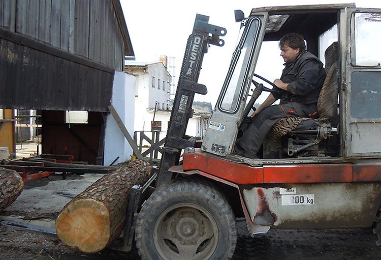 Uploading log to the sawmill with a tractor